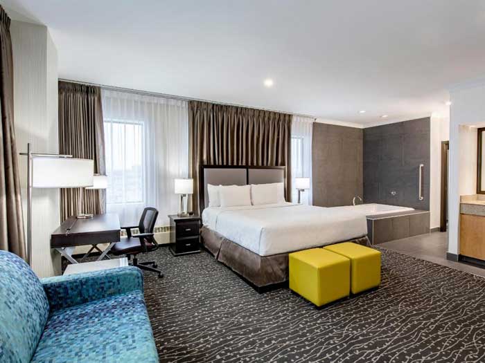 Executive Suite with a King size bed next to a deep 2-person jetted tub, also features 55-inch flat screen TV, electric fireplace, granite wet bar and lots of extra space.
